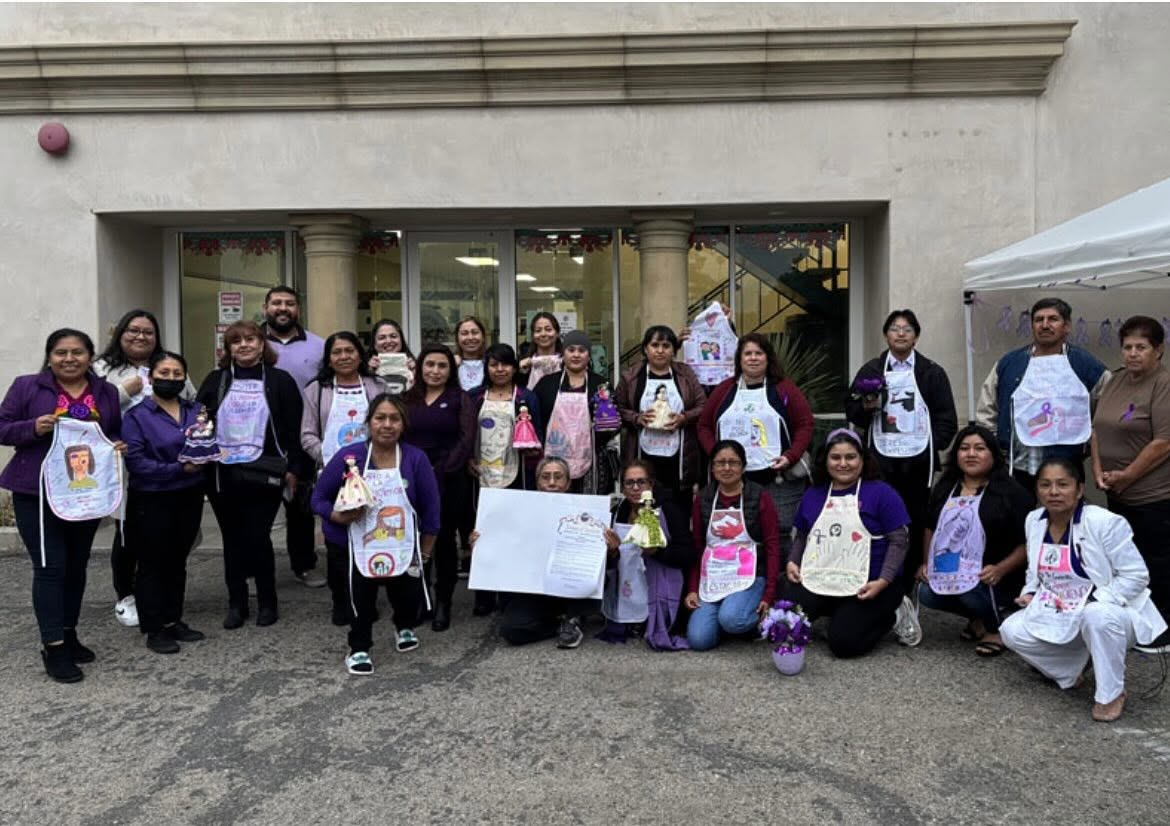 Community members displaying hand-decorated aprons at a Coalition awareness event