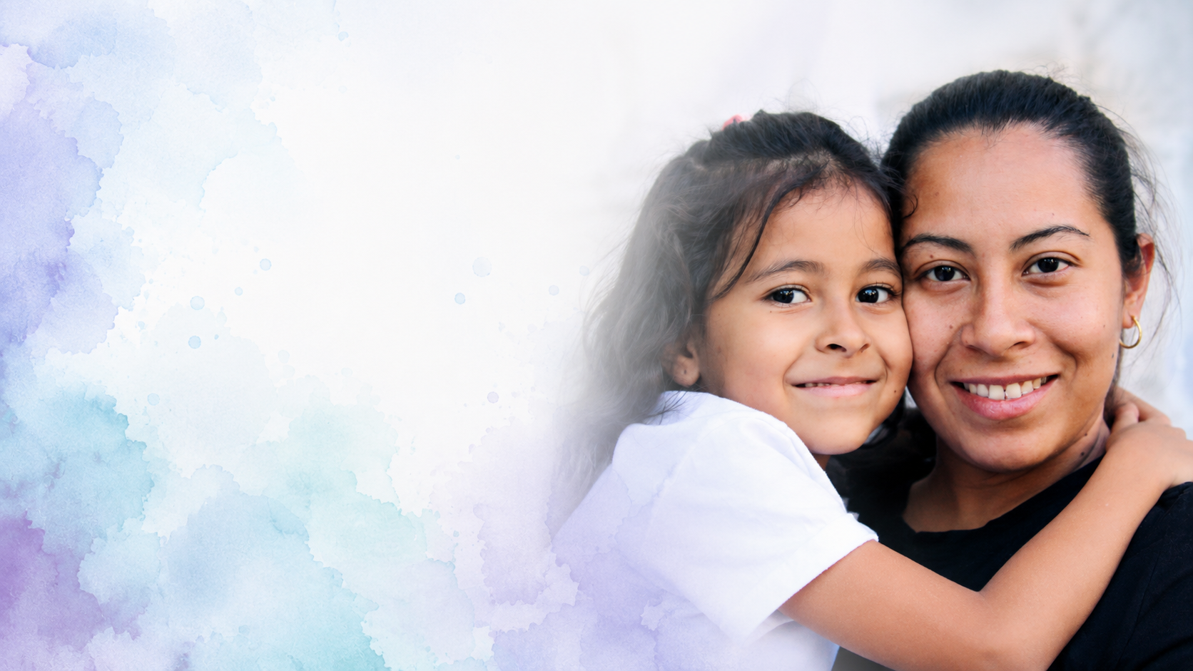 A mother holding her young daughter, both smiling