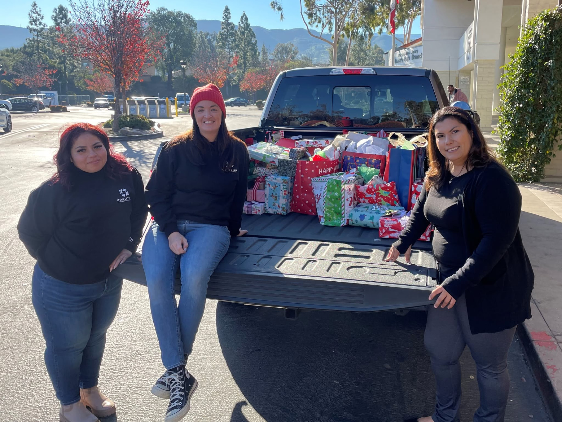 Volunteers with a truck full of donated holiday gifts for survivor families