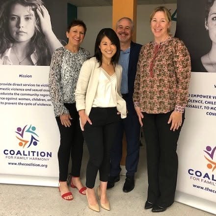 Coalition team members standing in front of the organization's mission banners